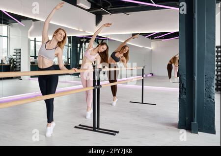 Flexible Tänzer üben Ballettbewegungen in der Ballettbar Stockfoto