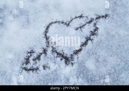 Valentinstag. Herz durch einen Pfeil gezeichnet auf Schnee durchbohrt. Stockfoto