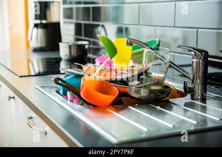 Das Waschbecken war voller schmutzigem Geschirr. Dunkle Arbeitsfläche in moderner Küche. Hausarbeit-Konzept Stockfoto