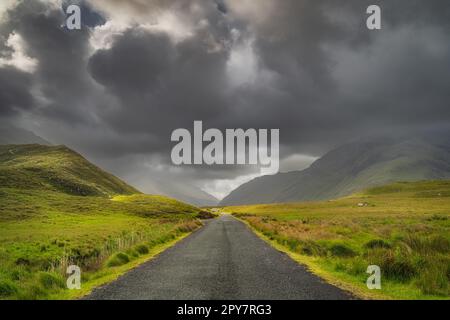 Straße, die durch das Doolough Valley führt, zwischen Bergketten, Irland Stockfoto