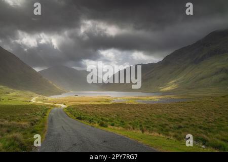 Die Straße führt durch das Doolough-Tal mit Seen, zwischen Bergketten, Irland Stockfoto