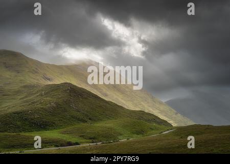 Doolough Valley, Glenummera und Glencullin Gebirgszüge beleuchtet von Sonnenlicht, Irland Stockfoto