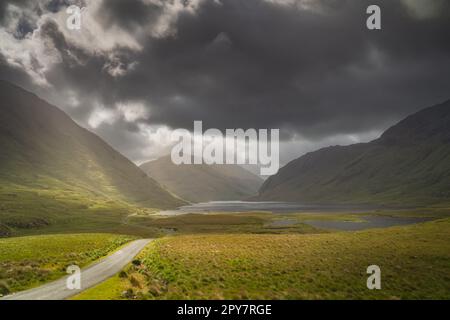 Die Straße führt durch das Doolough Valley mit Seen und Bergkette, Irland Stockfoto