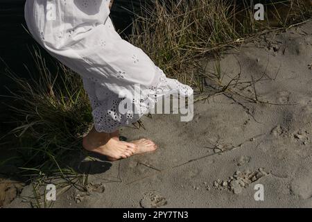 Nahaufnahme Frauenfüße auf nassem Sand Konzeptfoto Stockfoto