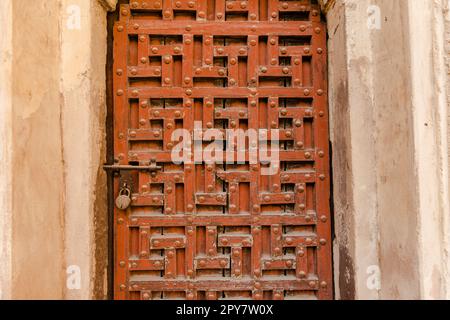 Eine Nahaufnahme der alten, verwitterten Holztür des Orchha Orchha Ortes Stockfoto