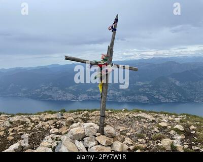 Blick auf ein Kreuz mit bunten Gebetsflaggen auf einem Berg Stockfoto