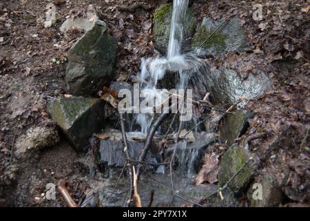 Flusslauf übersät mit Felsen mit Wasserfall im Siegerland Stockfoto