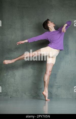 Männlicher Tänzer in dyanmischer Tanzhaltung im Fotostudio Stockfoto