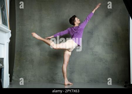 Männlicher Tänzer in dyanmischer Tanzhaltung im Fotostudio Stockfoto