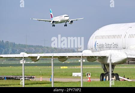 Stuttgart, Deutschland. 03. Mai 2023. Auf dem Flughafen Stuttgart, der Hauptstadt des Bundesstaates Baden-Württemberg, landet ein Passagierflugzeug. Im Vordergrund befindet sich ein Flugzeug des Flughafens, das für Rettungsübungen verwendet wird. Der Flughafen kündigt seine Geschäftszahlen für das vergangene Jahr auf einer Pressekonferenz an. Kredit: Bernd Weißbrod/dpa/Alamy Live News Stockfoto