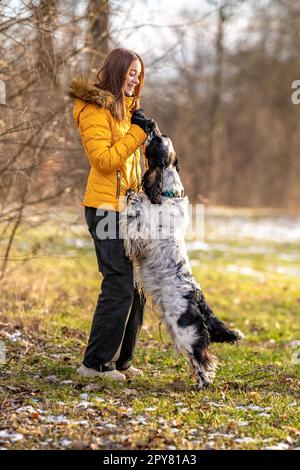 Junge Teenager spielen mit ihrem Hund in der Natur. englischer Setter Stockfoto