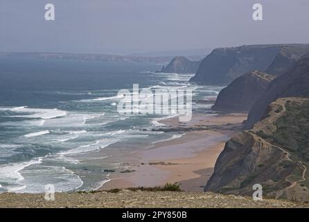 Wunderschöne Landschaften in Portugal. Malerische Küste in Vila do Bispo. Blick auf Praia da Cordoama von der Klippe. Welliges Meer. Rocky Skerries. Sonniger Frühlingstag Stockfoto