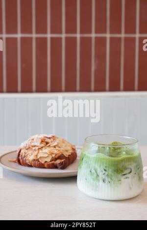 Grüner Eismatcha-Tee serviert mit Croissant Stockfoto