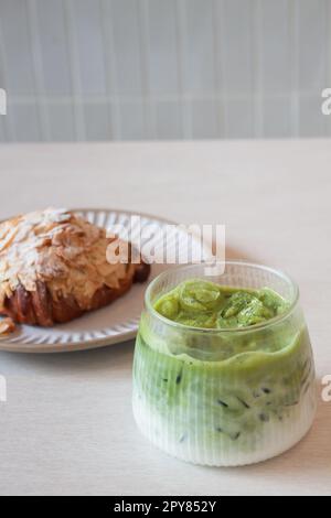 Grüner Eismatcha-Tee serviert mit Croissant Stockfoto
