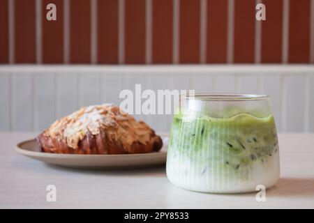 Grüner Eismatcha-Tee serviert mit Croissant Stockfoto