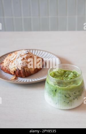 Grüner Eismatcha-Tee serviert mit Croissant Stockfoto