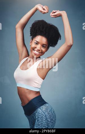 Ich fühle mich besser denn je. Studioaufnahme einer attraktiven jungen Frau in Sportkleidung vor grauem Hintergrund. Stockfoto