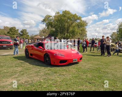 Red Sport Ferrari 360 Modena Coupe Berlinetta in einem Park. Natur, Gras, Bäume. CAACMACH 2023 Oldtimer-Show. Stockfoto