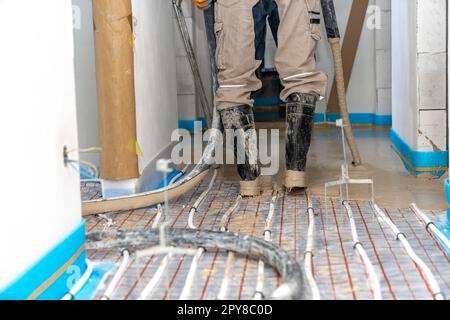 Abdeckung der Fußbodenheizung mit Anhydrid und Beton Stockfoto