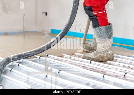 Installation von Beton und Anhydrit auf Fußbodenheizungen in einem neu gebauten Familienhaus Stockfoto