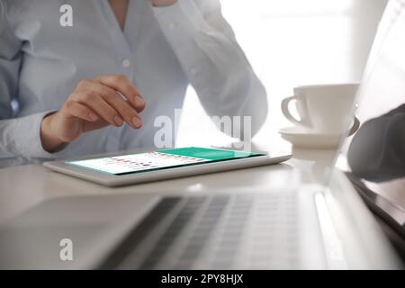 Frau, die ein modernes Tablet mit eingeschaltetem VPN am Tisch im Büro verwendet, Nahaufnahme Stockfoto