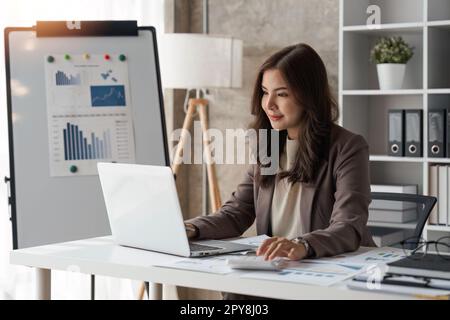 Geschäftsfrau verwendet einen Taschenrechner, um die Finanzen, Einnahmen und Budgets des Unternehmens zu prüfen. Geschäftsfrau, die monatliche Ausgaben berechnet, das Budget verwaltet Stockfoto