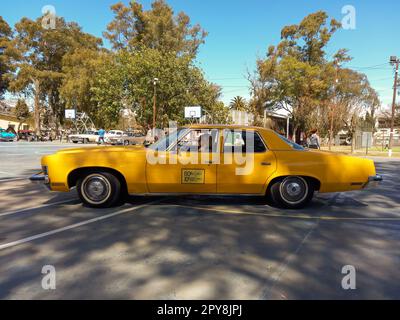 Lanus, Argentinien - 24. September 2022: Altes 1973 Pontiac Catalina 400 viertüriges gelbes Taxi in einem Park. Natur, Bäume. 2022 AAA Oldtimer-Show. Stockfoto