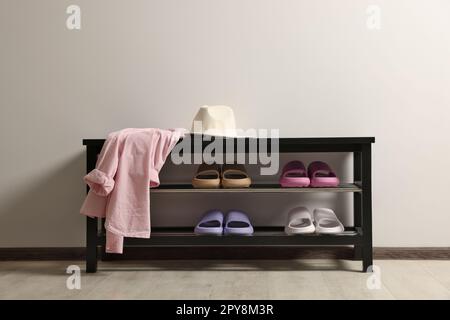 Aufbewahrungsbank mit Paar Gummipantoffeln im Zimmer Stockfoto