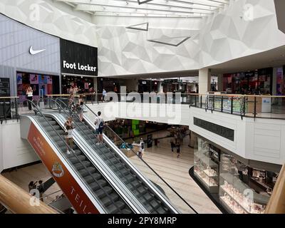 WARSCHAU, POLEN - 13. JULI 2022: Großes Einkaufszentrum mit vielen Geschäften und Rolltreppe Stockfoto