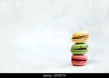 Französische bunte Makronen bunte Pastellmakronen auf weißem Hintergrund Pastellrosa und brauner Makronen mit frischem Blaubeeren, süßem Kuchenstapel Kopierraum Stockfoto