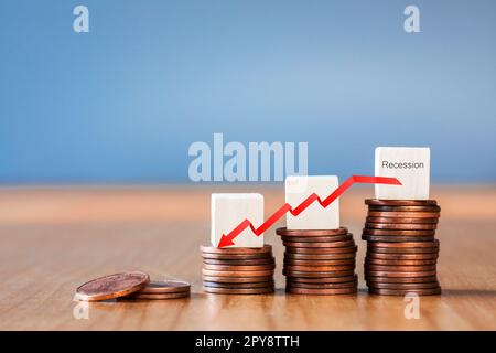 Inflation. Die Rezession der Wirtschaft und des Euro. Das Konzept des wirtschaftlichen Zusammenbruchs und des Zusammenbruchs der Börse in der Eurozone. Stapel von Münzen und ein nach unten zeigender Pfeil. Stockfoto