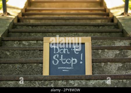 Kreidetafel mit dem Spruch „Halt nicht an steinernen Treppen im Freien“ Stockfoto