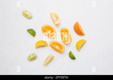 Ein Blick von oben auf mehrere Zitrusfrüchte auf einem einfachen weißen Hintergrund. Stockfoto