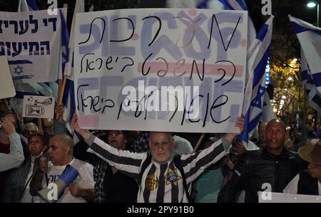 TEL AVIV, ISRAEL - APRIL 30: Ein rechtsgerichtlicher Demonstrant, der ein Scheinkostüm und einen gelben Stern trägt, hält ein Schild mit der Aufschrift "das Justizsystem in Israel ist ein Holocaust für das Volk Israels" auf einer Demonstration von Reformbefürwortern, die die Wiederaufnahme der Justizreform in der Nähe des Hauses von fordern Ehemaliger Präsident des Obersten Gerichtshofs, Aharon Barak, der am 30. April 2023 in Tel Aviv, Israel, einen lautstarken Kritiker des Plans der Regierung Netanjahu zur Überprüfung der Justiz war. Stockfoto