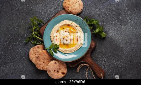 Hummus mit Olivenöl, Paprika, Zitrone und Pita-Brot. Klassischer Hummus auf dem Teller Stockfoto