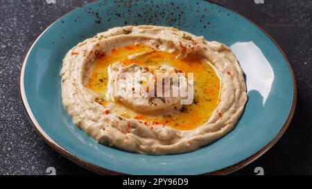 Hummus mit Olivenöl, Paprika, Zitrone und Pita-Brot. Klassischer Hummus auf dem Teller Stockfoto