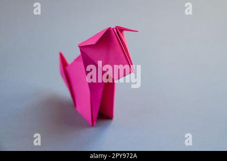 Rosa Papierhund Origami isoliert auf grauem Hintergrund Stockfoto