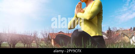 Frau, die im Freien auf dem Land meditiert. Stockfoto