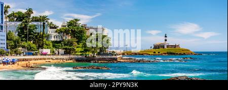 Panoramablick auf die Stadt Salvador in Bahia an einem sonnigen Tag mit dem Leuchtturm von Barra, dem Strand und den Gebäuden der Stadt, Brasilien Stockfoto