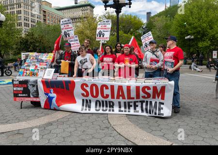 Eine Gruppe von Personen, die Schilder und Flaggen halten und bei einem friedlichen Protest auf dem Internationalen Tag der Arbeiter am Union Square im Mai zusammenstehen Stockfoto