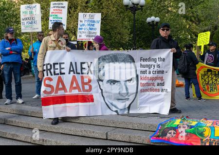 Eine Gruppe von Personen, die Schilder und Flaggen halten und bei einem friedlichen Protest auf dem Internationalen Tag der Arbeiter am Union Square im Mai zusammenstehen Stockfoto