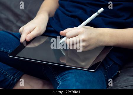 Digitaler Tablet-Computer mit leerem Bildschirm in männlicher Handnaht. Arbeiten Sie mit dem Eingabestift an Multitasking-Handheld-Geräten. Stockfoto