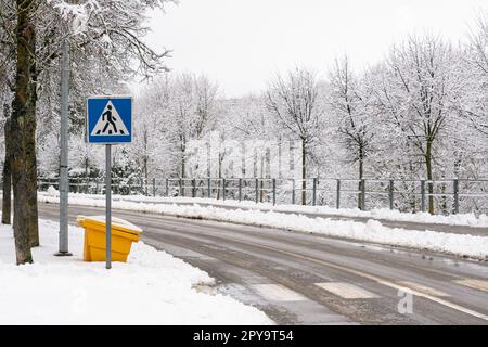 Blaues Straßenschild und Fußgängerkreuzung auf dem Asphalt Stockfoto