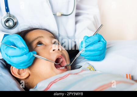 Arzt untersucht Mundhöhle des kleinen Kindes verwendet Mundspiegel zur Überprüfung der Zahnhöhle Stockfoto