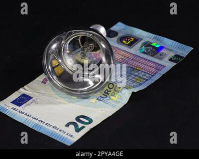 Abbildung einer 20-Euro-Banknote auf einer Glühbirne, die den Anstieg der Strompreise in der Eurozone und der Europäischen Union zeigt. Stockfoto