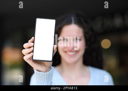 Eine glückliche Frau, die vor einem leeren Handy auftaucht Stockfoto