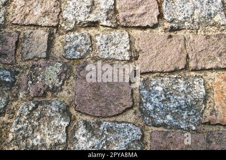 Kopfsteinpflaster-Naturstein mit Sandfugen. Hintergrundbild. Steinboden Stockfoto