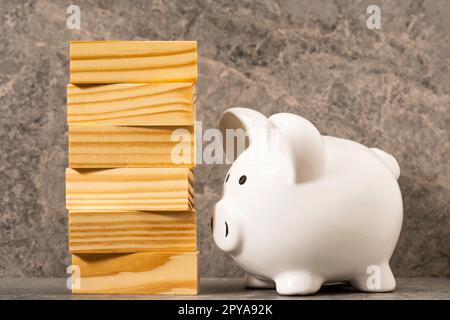 Sparschwein und Stapel aus Holzblöcken Stockfoto