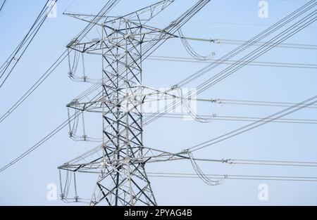 Hochspannungs-Stromübertragungsmast. Hochspannungsleitungen gegen den Himmel. Strompylon und elektrische Stromübertragungsleitungen. Hochspannungsturm liefert Stromversorgung. Energiekrise. Stockfoto