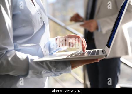 Frau, die ein modernes Notebook mit eingeschaltetem VPN im Büro verwendet, Nahaufnahme Stockfoto